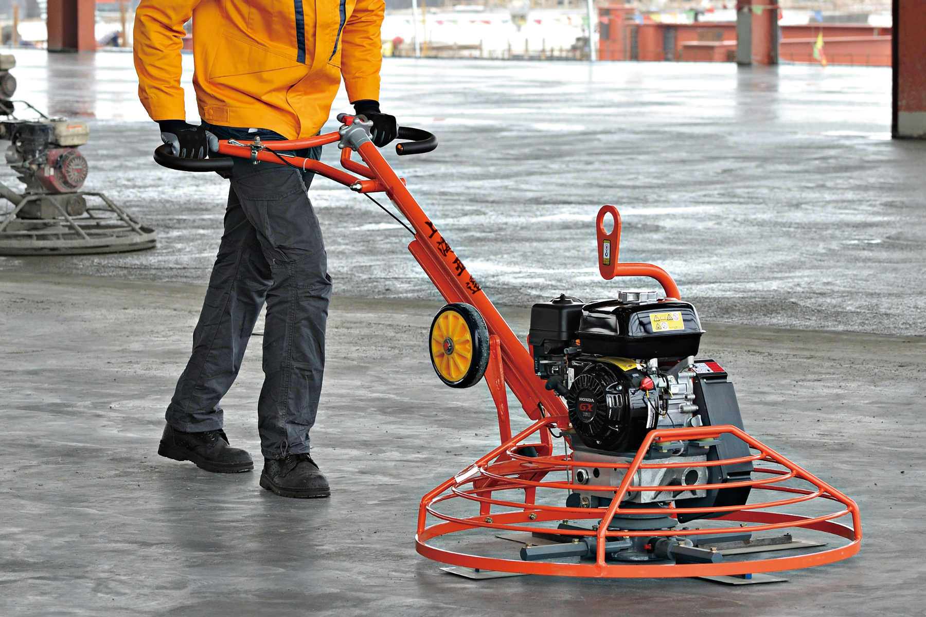 Operator using Conmec CT436 walk-behind power trowel on concrete floor